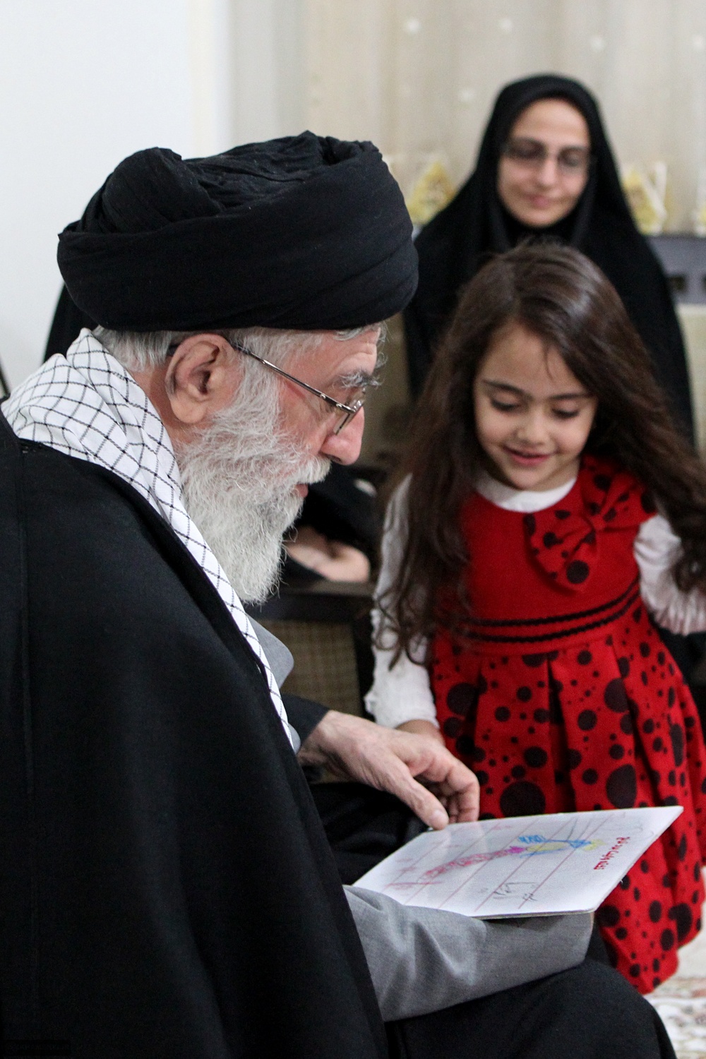 「核の殉教者」レザーイーネジャードの家庭を訪問し、娘のアールミーターと接するハーメネイー最高指導者（2012年1月19日）。優しい父親としての最高指導者像が演出されている（khamenei.irより）
