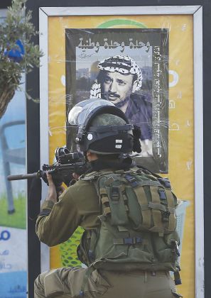 アラファート氏命日、ポスター前のイスラエル兵（AFP）