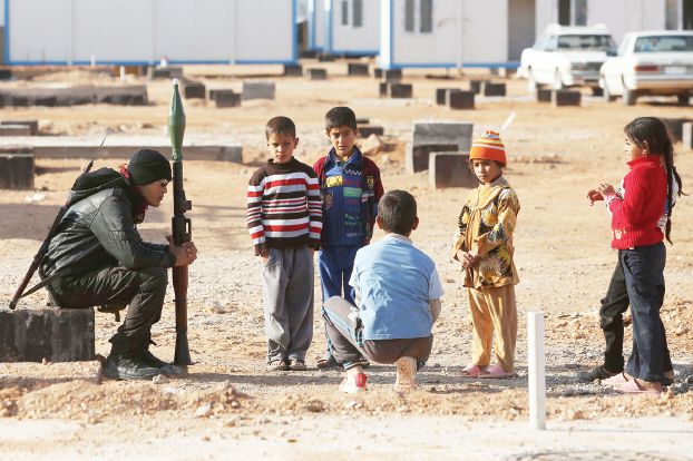 ヌヒブの難民キャンプで警備兵の周りに集まる子供たち（AFP）
