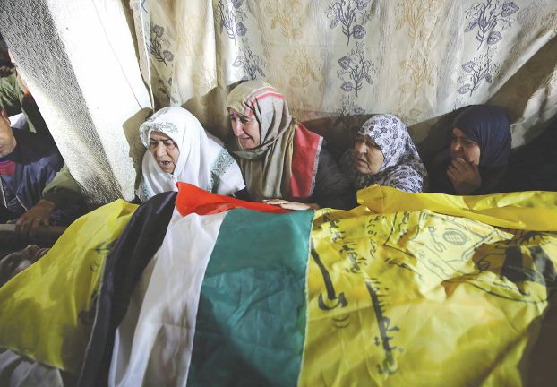 昨日、ガザのハーン・ユーニスで行われた葬儀にて、殉教者ムハンマド・キータ（26歳）との別れを惜しむ遺族（AP）