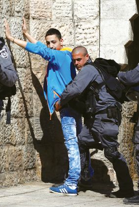 エルサレムのダマスカス門にてパレスチナ人青年を取り調べるイスラエル警察（AFP）