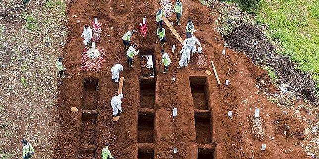 写真）去る4月26日、ジャカルタ・ポンドック・ランゴン霊園にて新型コロナウイルスによる死者の埋葬作業にあたる職員。