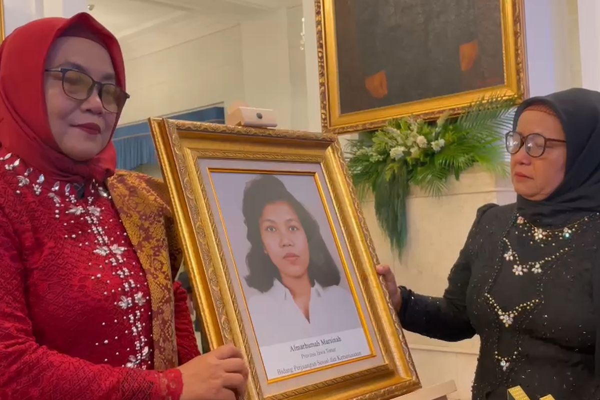 国家英雄の授与式のあと、妹の写真を掲げるマルシナの姉